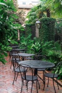 black metal patio tables near green plants during daytime
