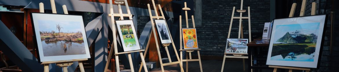 five assorted paintings on easels